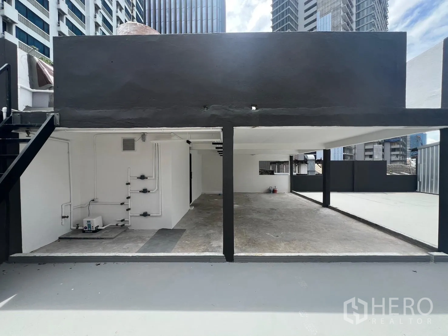 พื้นที่ขายของ for rent in Bang Rak, Bangkok - พื้นที่เปิดด้านข้างเผยให้เห็นงานท่อและระบบไฟ ใต้เพดานสีขาวและเสาค้ำสีดำ.