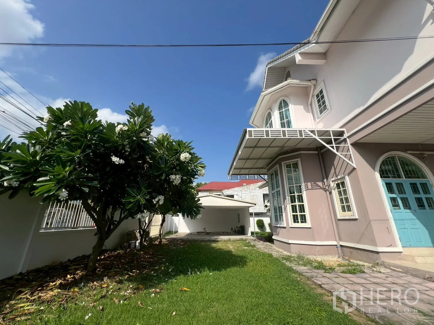 บ้าน ขายในPhra Khanong, Bangkok - สวนข้างบ้านพร้อมทางเดินหญ้า ประตูสีน้ำเงินและหน้าต่างบานเบย์