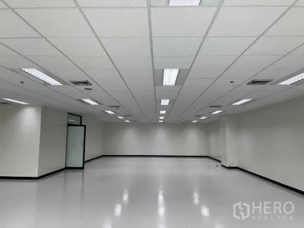 办公空间 出租在Bang Na, Bangkok - 大型办公楼层，格栅吊顶、嵌入式灯具、空调出风口与玻璃门