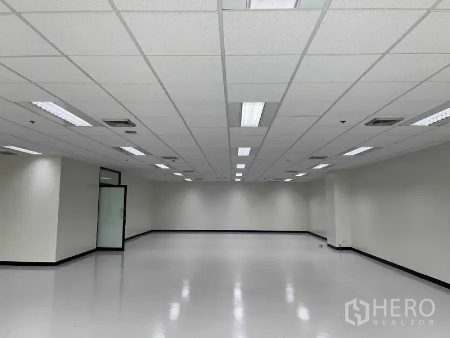 办公空间 出租在Bang Na, Bangkok - 大型办公楼层，格栅吊顶、嵌入式灯具、空调出风口与玻璃门