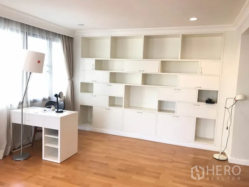 Condominium for rent in Sathon, Bangkok - Light-filled study or family room with built-in white shelving and desk.