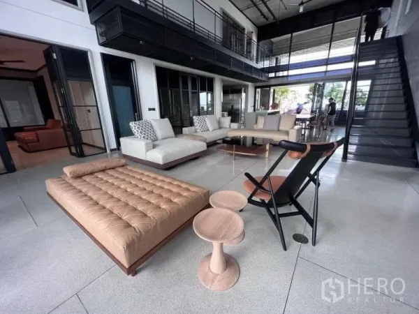 公寓 出租在Sathon, Bangkok - 挑高双层客厅，落地窗与中性色沙发，现代休闲座椅。