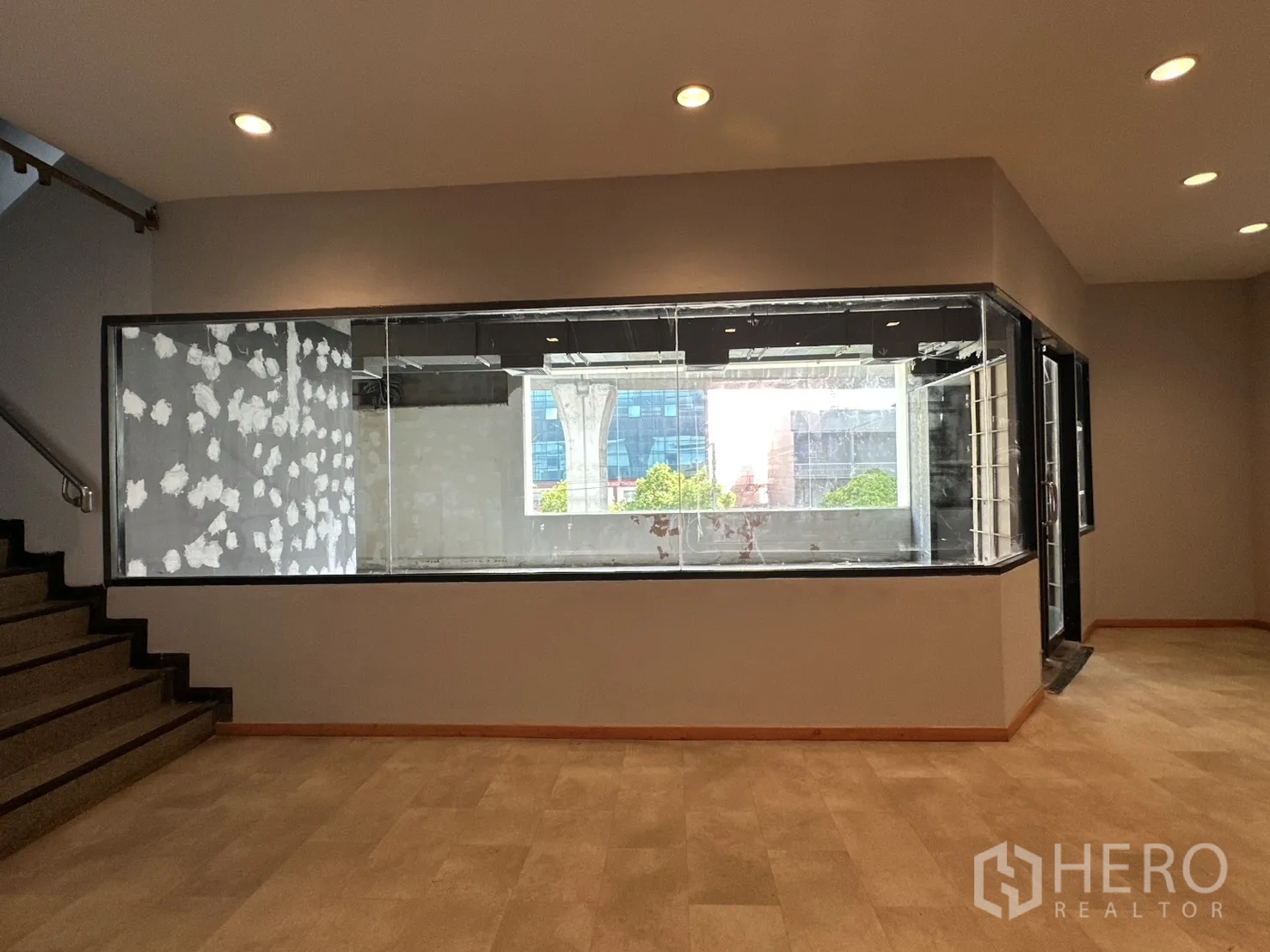Retail Space for rent in Watthana, Bangkok - Interior area with a large glass display window, recessed lights, and a staircase.
