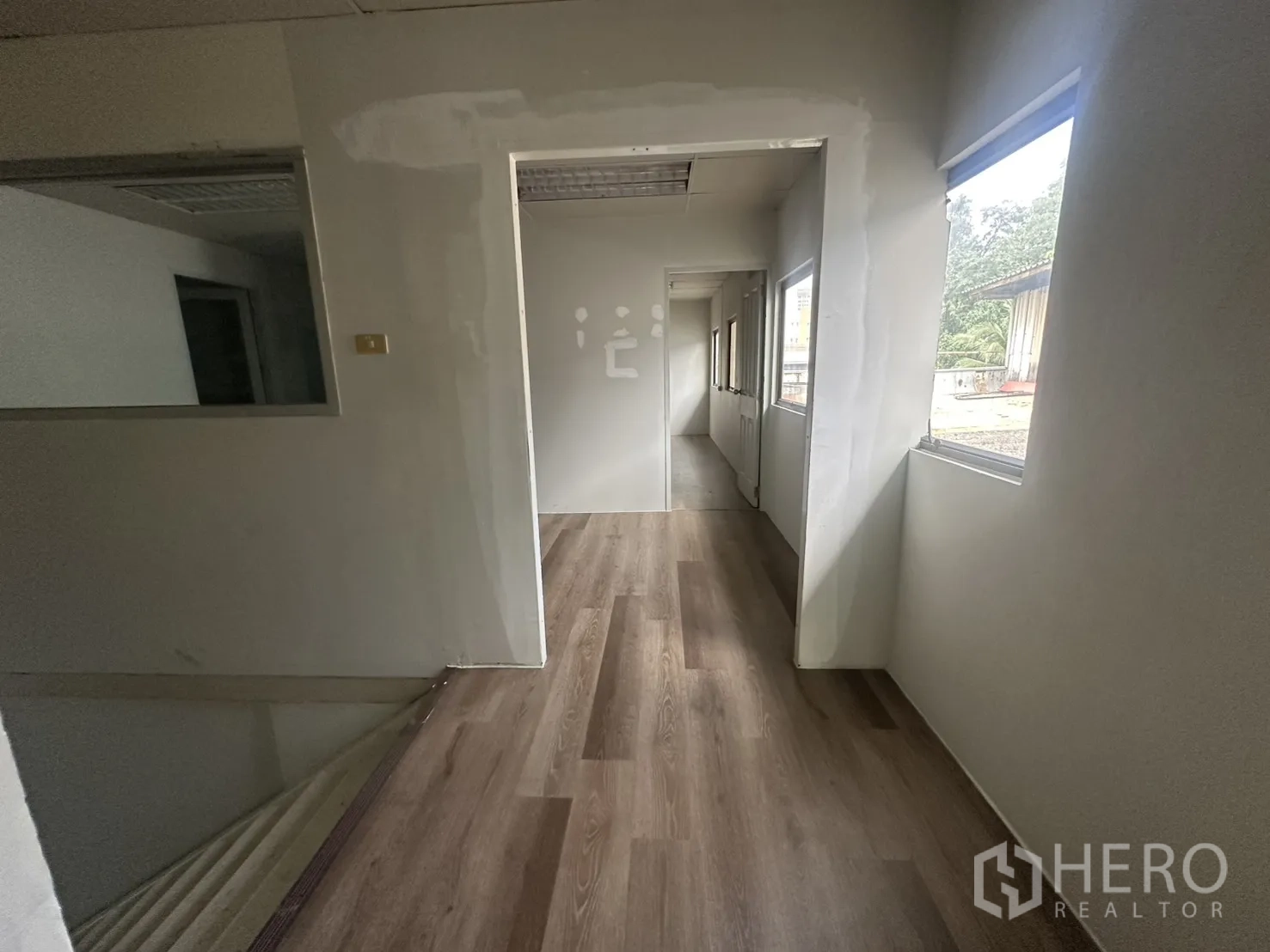 Warehouse for rent in Suan Luang, Bangkok - Upper corridor with laminate floor and multiple windows.