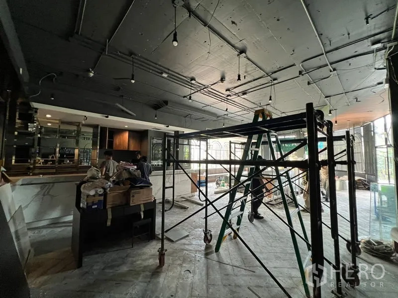 พื้นที่ขายปลีก ให้เช่า - พื้นที่ภายในกว้างอยู่ระหว่างปรับปรุง เพดานเปิดเปลือย เคาน์เตอร์บาร์ และนั่งร้าน