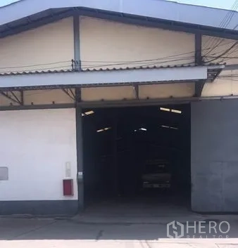 Warehouse for rent in Chachoengsao - Warehouse entrance with large steel sliding doors, gable roof and covered loading area in Bang Pakong.