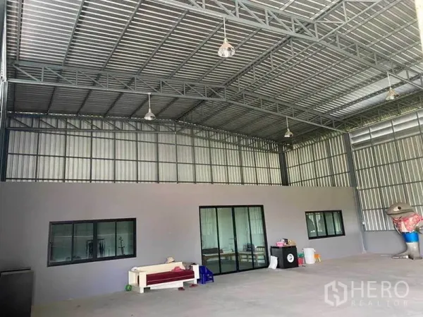 Warehouse for rent in Sam Phran, Nakhon Pathom - Warehouse interior showing office block with glass doors and windows beneath a high ceiling.