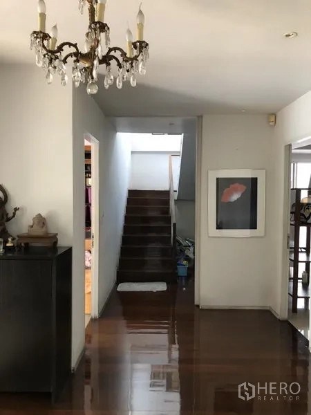 Detached House for rent in Chatuchak, Bangkok - Entrance hall with chandelier, polished wooden floors and staircase to upper level.