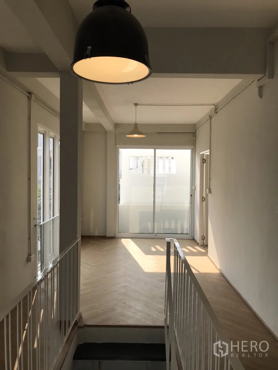 บ้าน ให้เช่าหรือขายในDin Daeng, Bangkok - โถงชั้นบนสว่าง ไฟแขวน พื้นลายก้างปลา และประตูกระจกบานเลื่อน