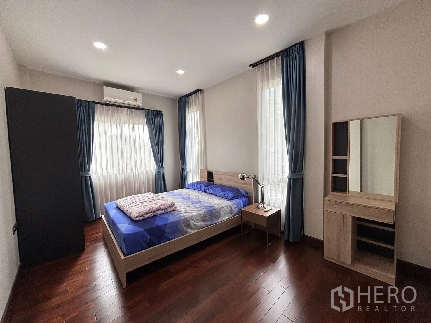 Detached House for rent in Bang Phli, Samut Prakan - Bright bedroom with double bed, wood floors, curtains and dressing table.