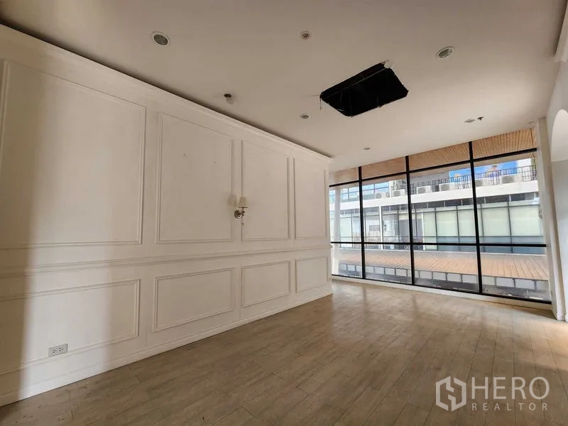 Office Space for rent in Yan Nawa, Bangkok - Open-plan office room featuring white paneled walls and full-height windows.