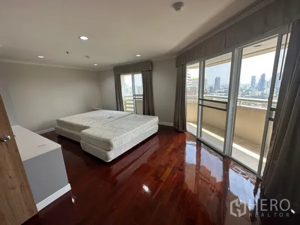 คอนโด ให้เช่าในWatthana, Bangkok - ห้องนอนมุมกว้าง พื้นไม้เงา ประตูกระจกหลายชุดออกสู่ระเบียงรอบมุม มองเห็นวิวเมือง