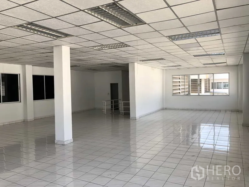 货栈 出租在Phra Nakhon Si Ayutthaya - 开放式办公室，亮面瓷砖地、格栅吊顶与多扇窗采光。