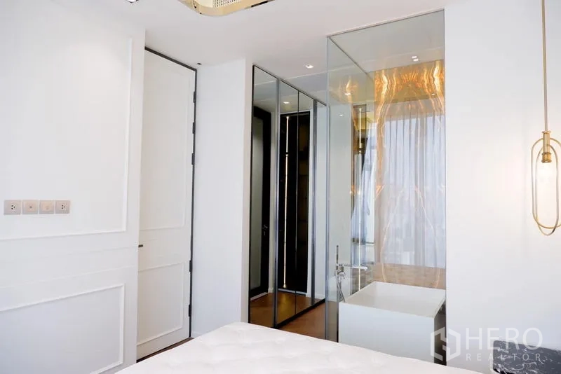 公寓 出租在Pathum Wan, Bangkok - 卧室一角，镜面衣柜与玻璃围合的浴缸