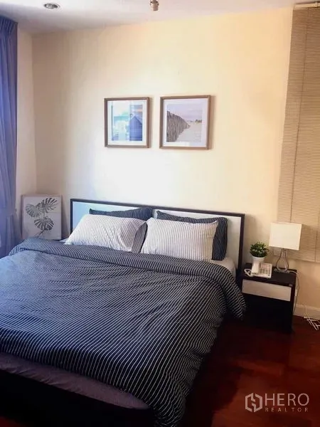 คอนโด ให้เช่าในKhlong Toei, Bangkok - ห้องนอนอบอุ่นเตียงคู่ โต๊ะข้าง และกรอบรูปบนผนัง