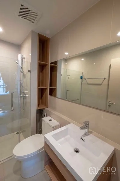 คอนโด ให้เช่าในBang Na, Bangkok - ห้องน้ำโมเดิร์นพร้อมตู้กระจกกั้นอาบน้ำ อ่างล้างหน้า และชั้นเก็บของ