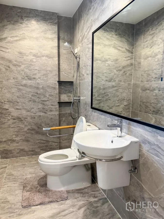 Detached House for rent or sale in Bueng Kum, Bangkok - Secondary bathroom with walk-in shower, wall-mounted sink and gray stone tiles.