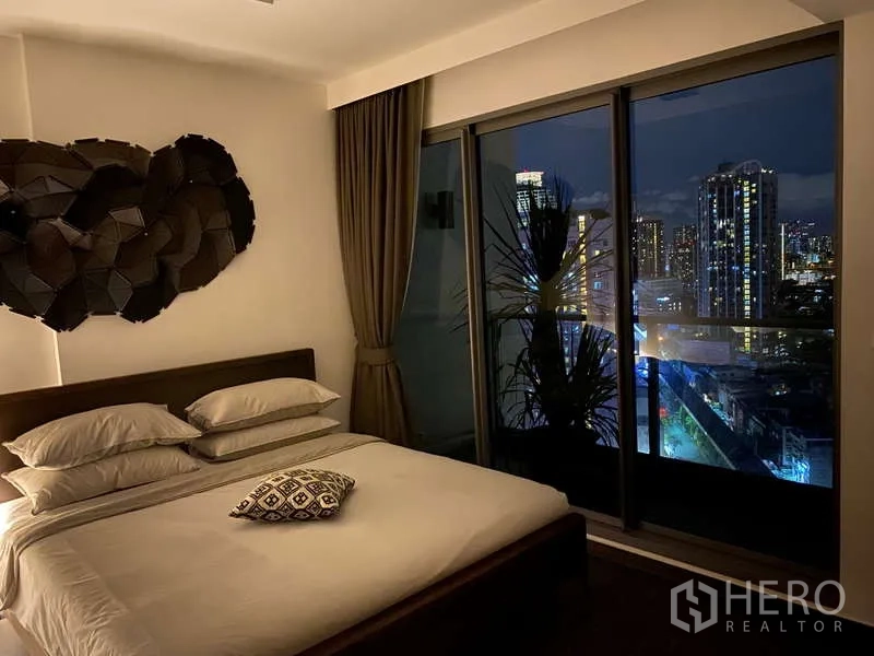 คอนโด ขายในWatthana, Bangkok - ห้องนอนมาสเตอร์ยามค่ำ มีกระจกเต็มผนัง มองเห็นวิวเมืองพาโนรามา