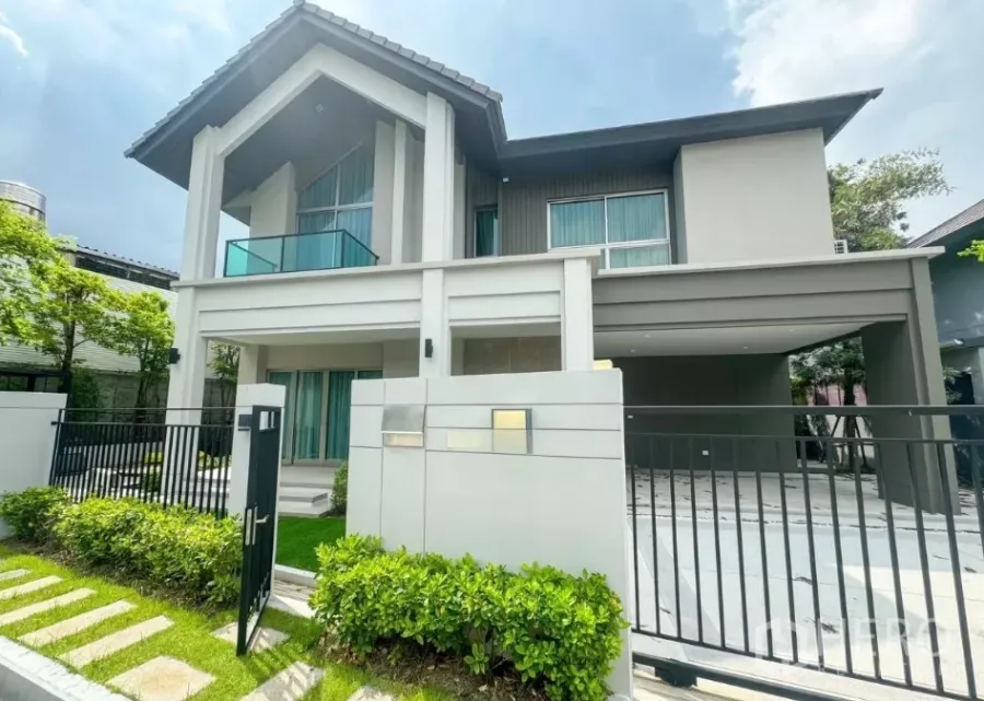 Detached House for rent or sale in Bueng Kum, Bangkok - Modern two-storey detached house facade with gated entry, landscaped hedge and covered four-car parking.