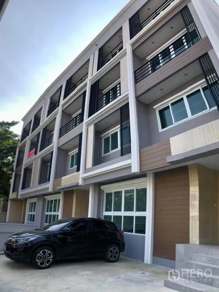 带办公室的家 出租在Prawet, Bangkok - 现代多层家用办公楼外立面，设阳台与前院停车区。