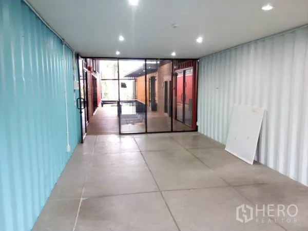 零售空间 出租在Khlong Toei, Bangkok - 长方形店铺，推拉玻璃门面通向庭院。