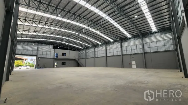 Factory for rent or sale in Bang Bo, Samut Prakan - Vast warehouse hall with high clear span, steel truss roof and smooth concrete floor ready for production.