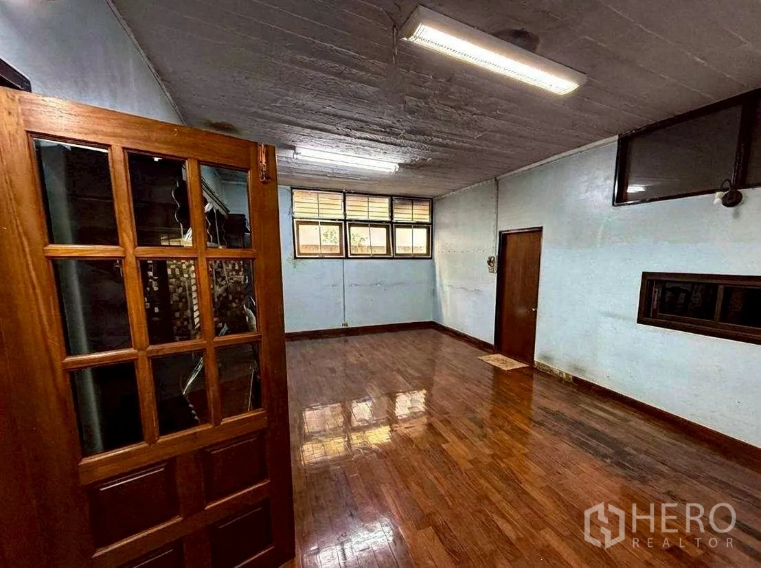 Home Office for rent in Bang Rak, Bangkok - Simple room with small high windows, wooden floor and fluorescent lights.