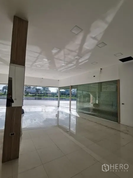 零售空间 出租在Bueng Kum, Bangkok - 开放式瓷砖零售区，玻璃墙与卷帘门