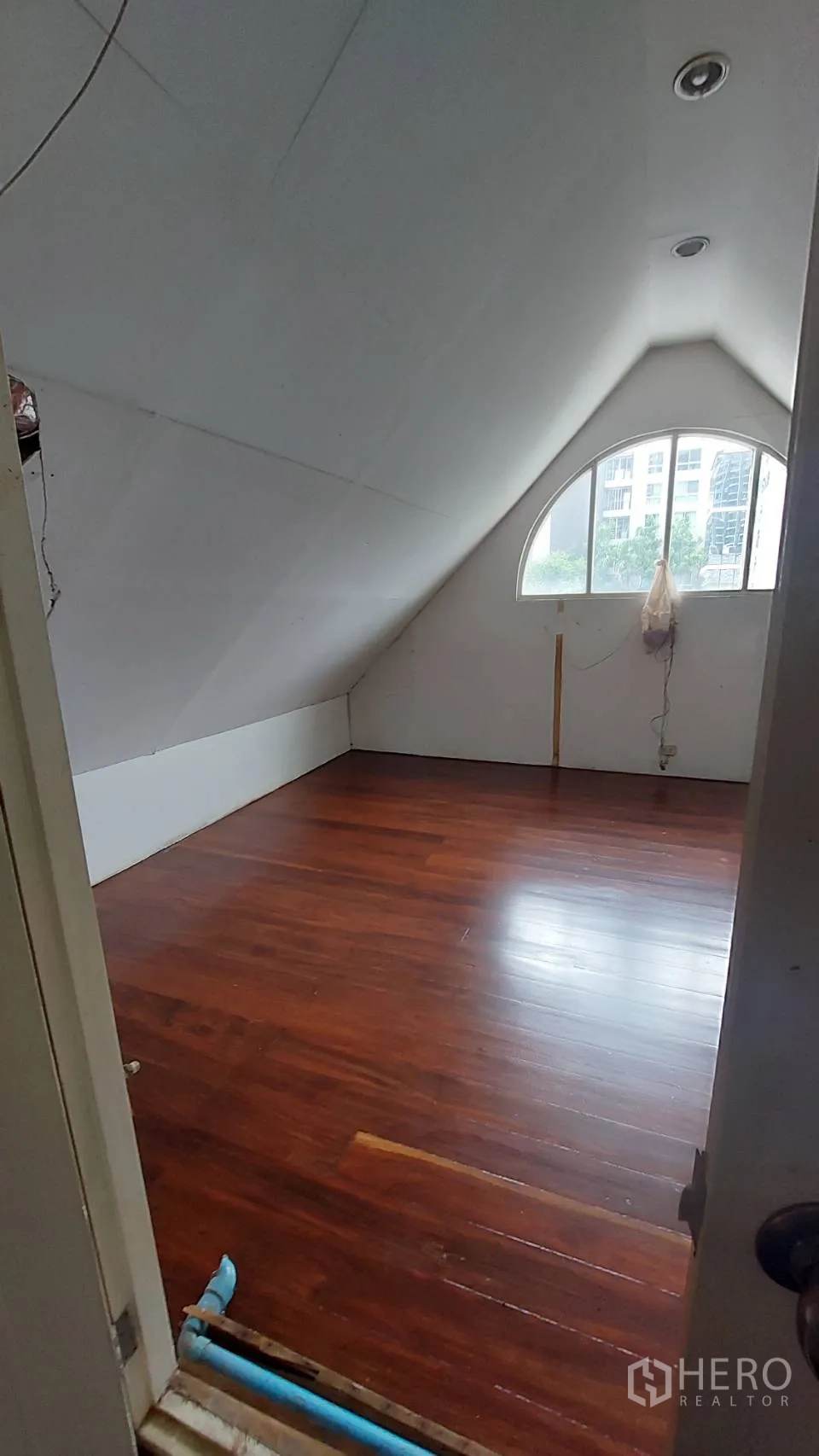 สำนักงาน ให้เช่าในWatthana, Bangkok - มุมมองจากประตูสู่พื้นที่ทำงานสไตล์ห้องเพดานลาด หน้าต่างโค้ง ไฟดาวน์ไลท์ และพื้นไม้เงางาม