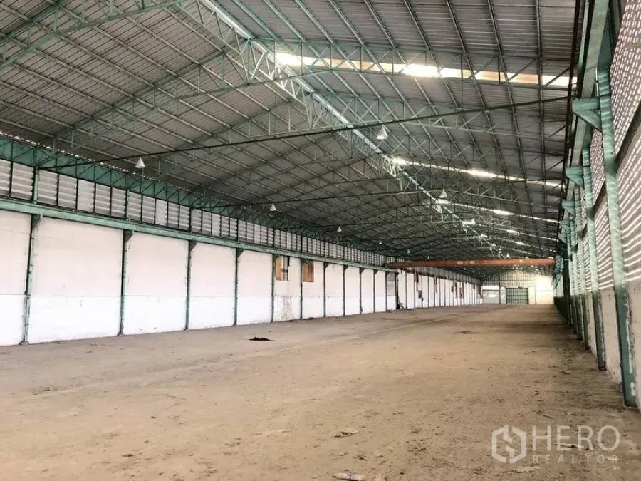 Warehouse for rent in Samut Prakan - Spacious warehouse interior featuring a high steel truss roof and open clear floor.