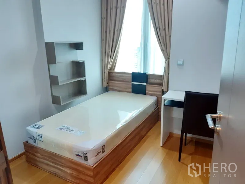 คอนโด ให้เช่าในKhlong Toei, Bangkok - ห้องนอนเล็กอบอุ่น เตียงเดี่ยว โต๊ะทำงานริมหน้าต่าง ชั้นวางของ และพื้นไม้โทนอุ่น