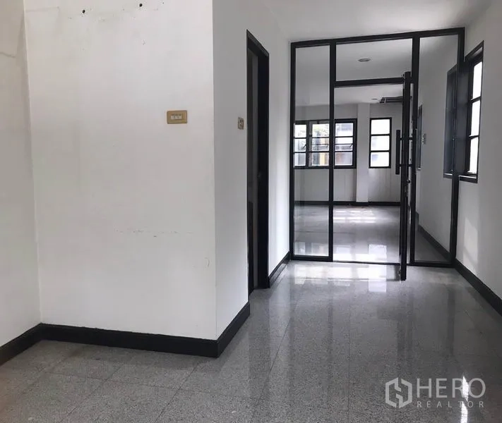 零售空间 出租在Watthana, Bangkok - 走廊与玻璃隔断门，连接明亮的房间