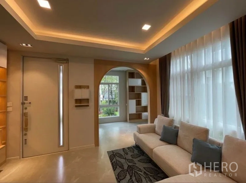 บ้าน ให้เช่าในPrawet, Bangkok - ห้องนั่งเล่นสว่างของบ้านเดี่ยวในเขตประเวศ เพดานซ่อนไฟ ช่องแสงขนาดใหญ่ และซุ้มโค้งทางเข้า