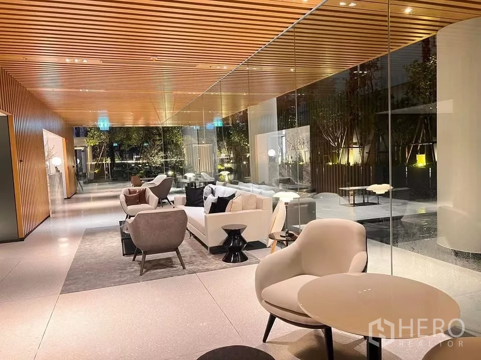 公寓 出租在Bang Rak, Bangkok - 酒店式大堂，木格天花与落地玻璃，外接花园景观。