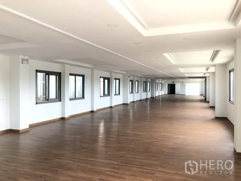 工厂 出租或出售在Samut Prakan - 大开间办公层，木纹地板与成列窗户。