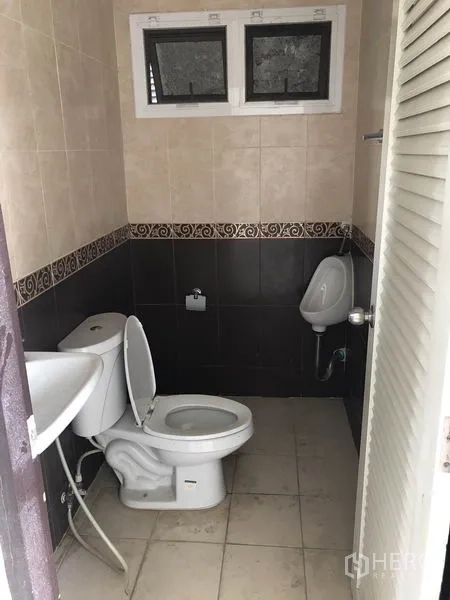 货栈 出租或出售在Lam Luk Ka, Pathum Thani - 整洁的瓷砖卫生间，配坐便器、洗手盆和小便器。