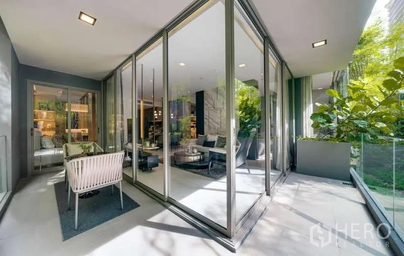 คอนโด ให้เช่าในWatthana, Bangkok - ระเบียงกว้างล้อมกระจก มองเห็นต้นไม้ พร้อมชุดโต๊ะเก้าอี้