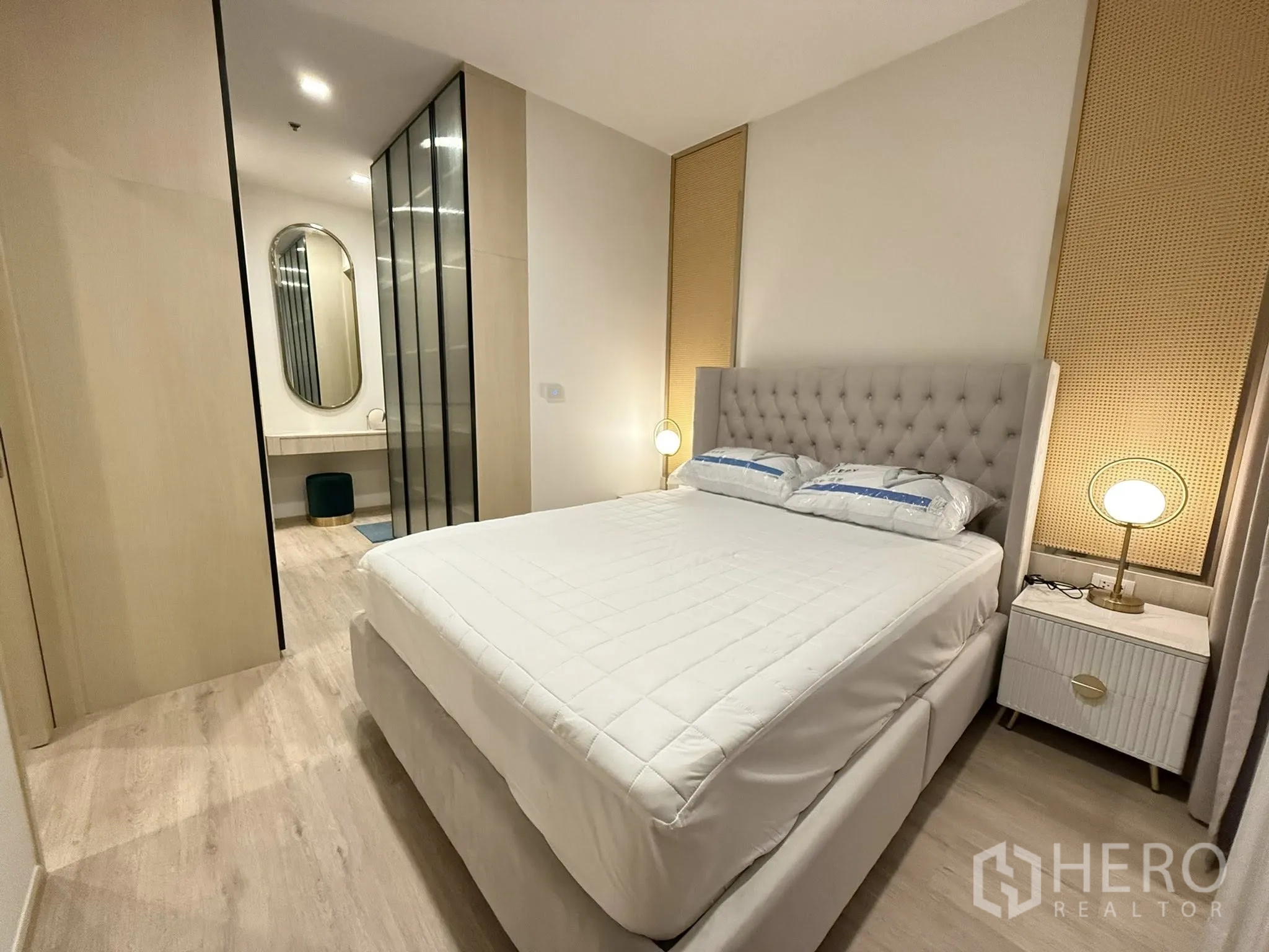 公寓 for rent in Watthana, Bangkok - 卧室设软包床、床头灯、大衣柜和带椭圆镜的梳妆区。