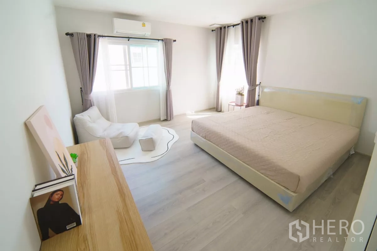 Detached House for rent in Bang Phli, Samut Prakan - Second bedroom with king bed, dresser and a lounge chair by the window.