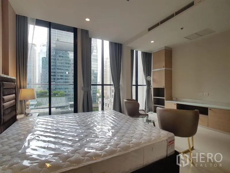 คอนโด ให้เช่าในPathum Wan, Bangkok - ห้องนอนพร้อมหน้าต่างสูงรอบด้าน โต๊ะบิลท์อิน มองเห็นสกายไลน์กรุงเทพฯ