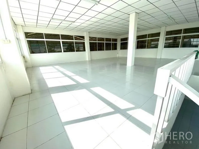 Warehouse for rent in Lam Luk Ka, Pathum Thani - Sunlit mezzanine office with tiled floor and windows overlooking the warehouse.