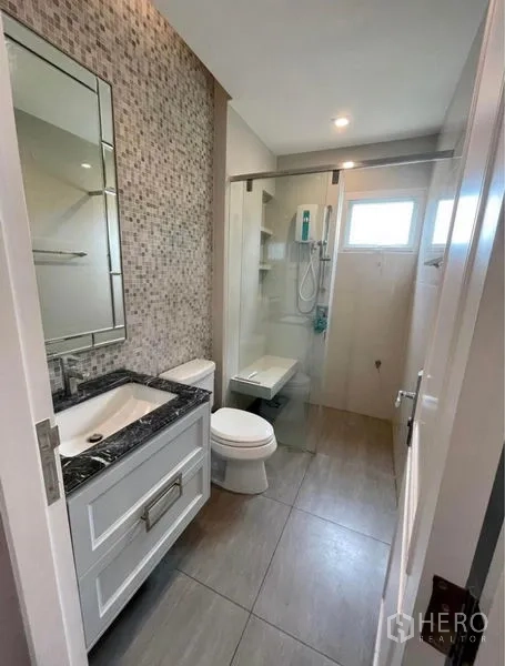 Detached House for rent in Bang Phli, Samut Prakan - Compact bathroom featuring mosaic wall tiles and a glass-enclosed shower.