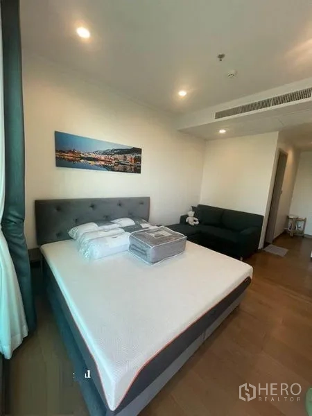 公寓 出租在Watthana, Bangkok - 明亮卧室，软包床、沙发与木地板。