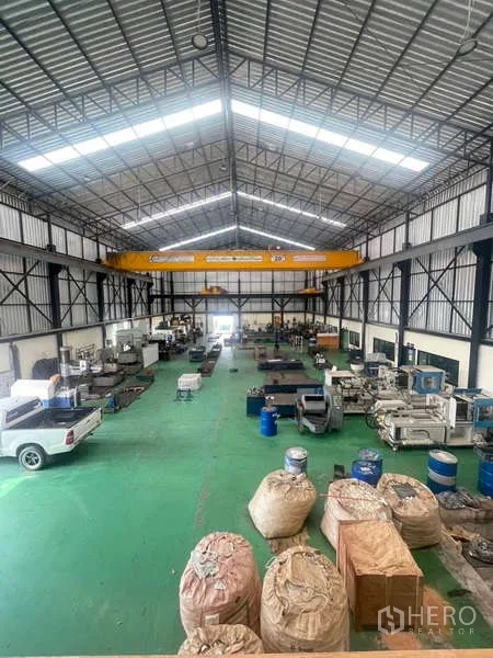 工厂 出售在Si Racha, Chon Buri - 俯瞰生产大厅，见龙门行车、皮卡与材料堆放。