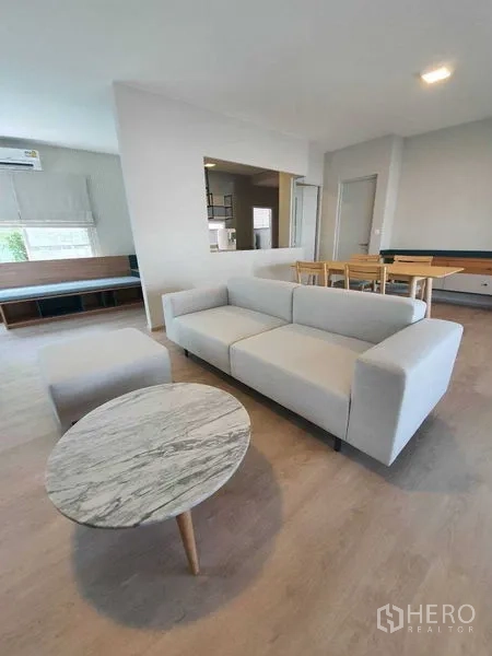 Townhouse for rent - Open-plan living room with sofa, marble coffee table, and dining set.