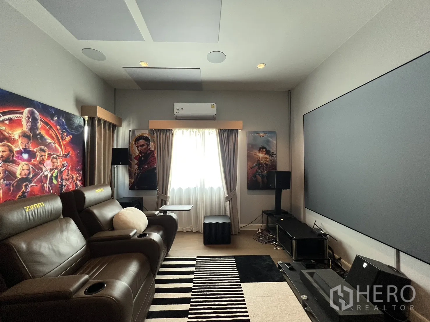 Detached House for rent or sale in Mueang Pathum Thani, Pathum Thani - Cinema room view toward the entrance with speakers and posters.