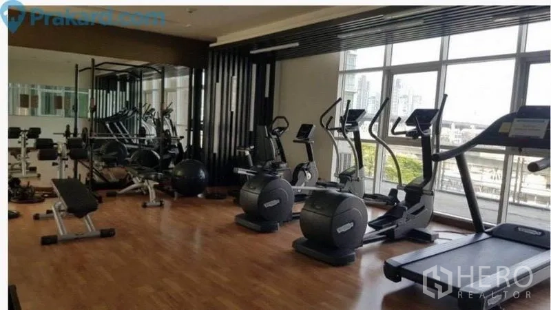 Condominium for sale in Bang Na, Bangkok - Fully equipped fitness room with treadmills, exercise bikes, weights and mirrored wall.