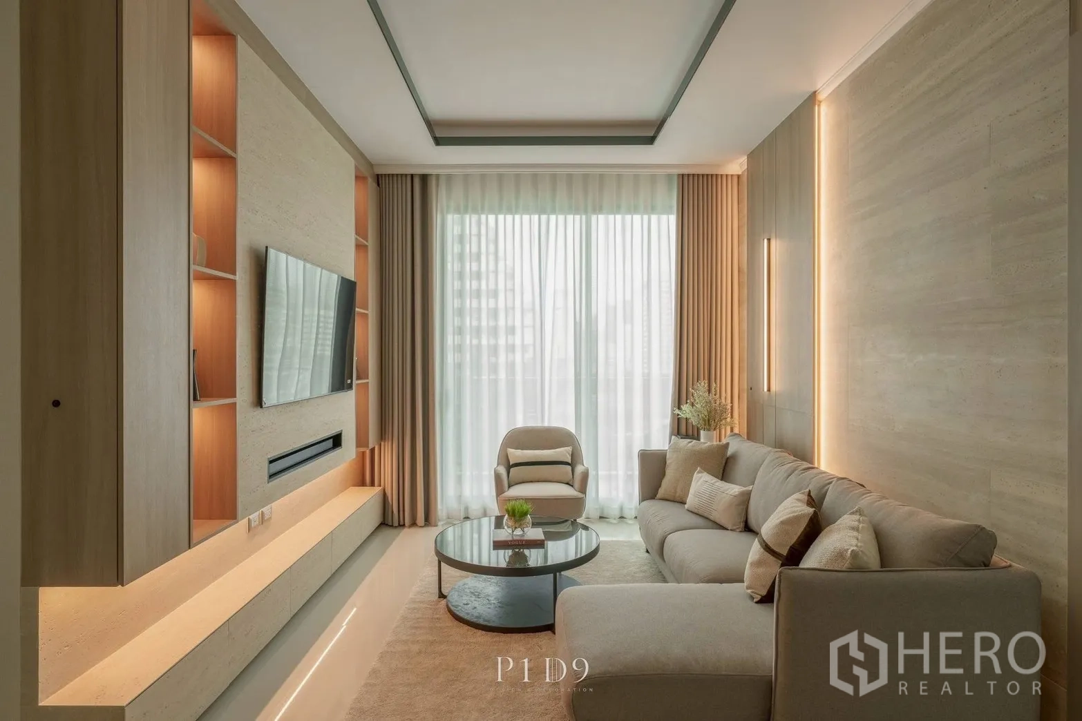 Condominium for rent in Watthana, Bangkok - Elegant living room with feature lighting, wall-mounted TV, and coffee table.