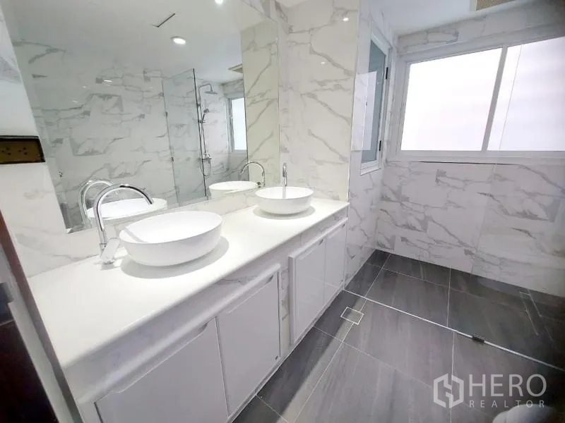 คอนโด ให้เช่าในWatthana, Bangkok - ห้องน้ำสมัยใหม่ อ่างล้างหน้าคู่ กระจกบานใหญ่ และฝักบัวกระจก ผนังลายหินอ่อน