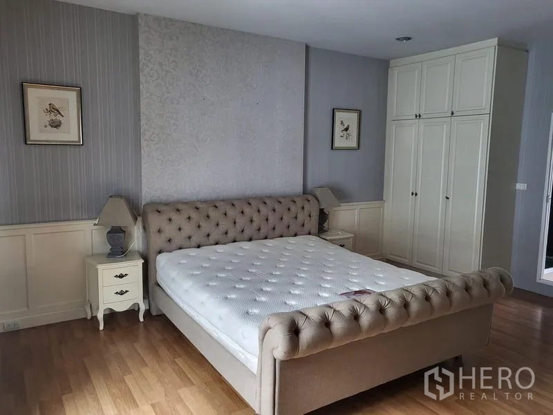 Townhouse for rent in Wang Thonglang, Bangkok - Master bedroom featuring upholstered bed, nightstands and built-in wardrobe.